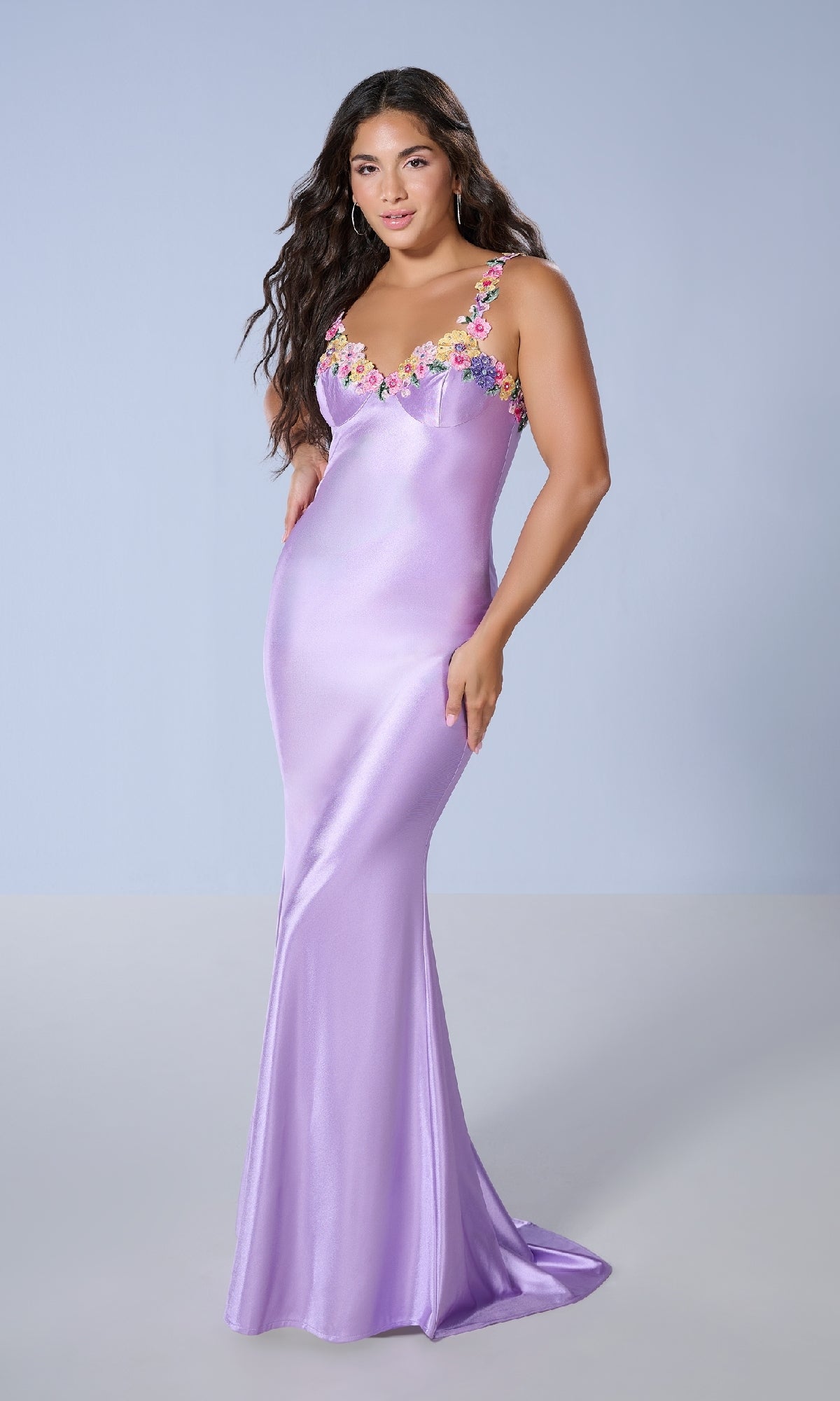 A woman in the Long Prom Dress: Tiffany 16145, a slim-fit, floor-length lavender gown with floral embellishments on the straps and neckline, stands against a light gray background.